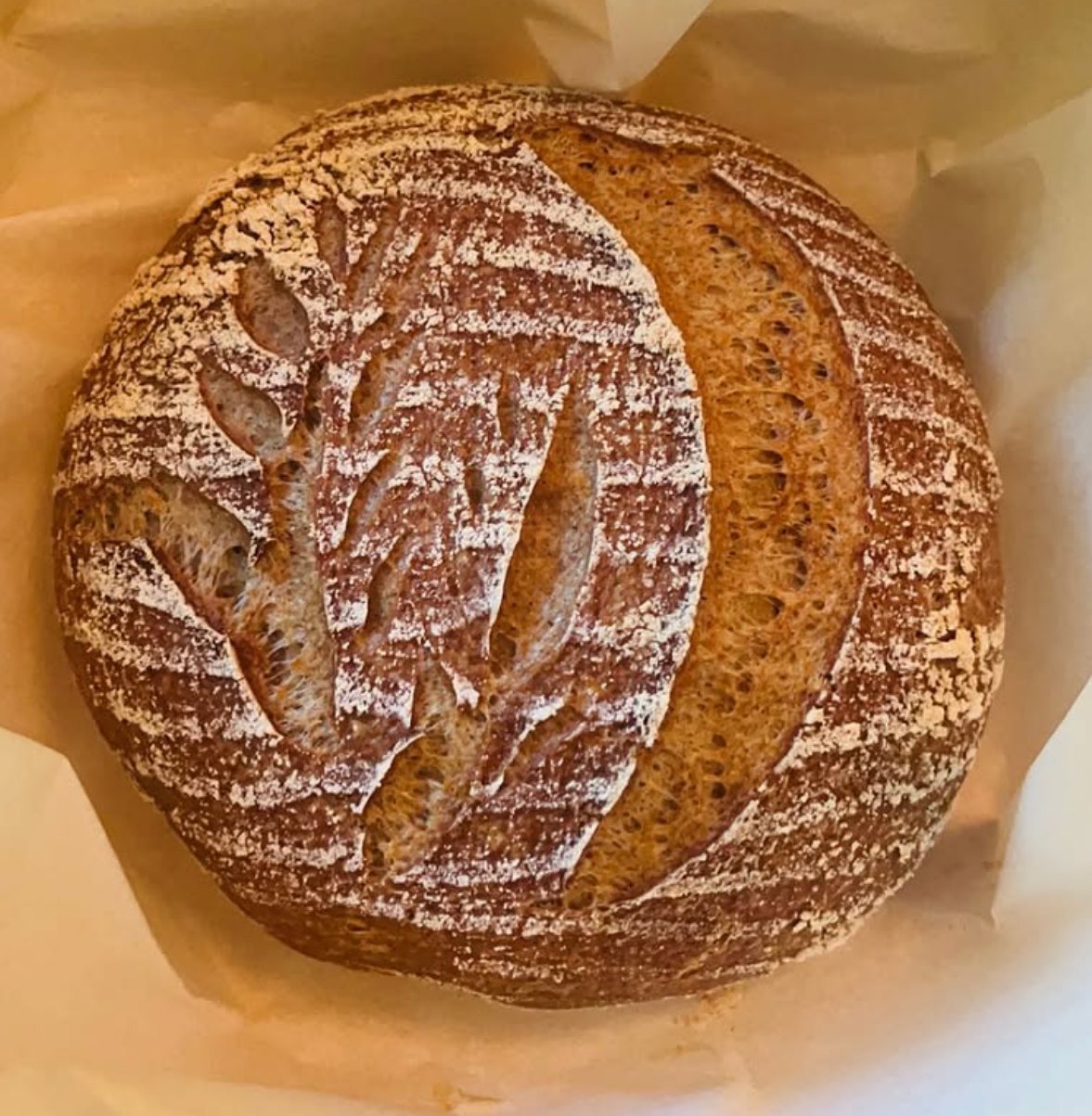 Hand-scored gluten-free sourdough loaf with wheat design